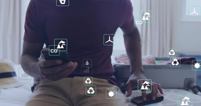 Man tapping phones on hotel bed, causing floating icons and presenting vaccination proof QR code