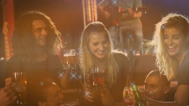 Trio leaning as green bottle moving, friends raising drinks toasting bar with sparkles on glasses