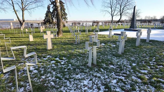 Ukrainian military cemetery with modern openwork metal crosses, soldiers' graves in a winter landscape with snow, historical war memorial and national heritage site under a clear blue sky.