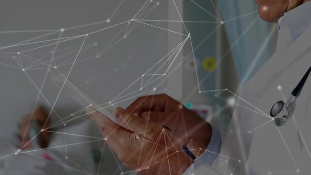 Male doctor tapping tablet causing network over monitors and reviewing patient on O2 guiding care