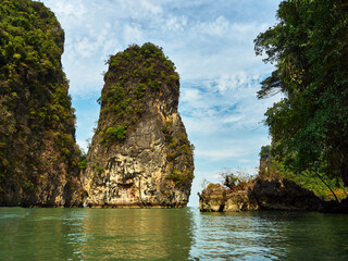 Obraz premium Islands in the Andaman Sea, Thailand. Beautiful scenery, high, steep cliffs covered with shrubs and trees, a famous Thai destination.