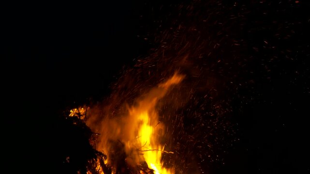 Large Bonfire with Flying Embers behind Barbed wire