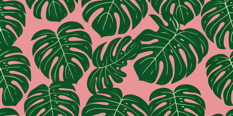 A seamless pattern of vibrant green monstera leaves on a pink background © PolyRani
