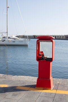Red fire hydrant alongside docked sailboat in acciaroli harbor