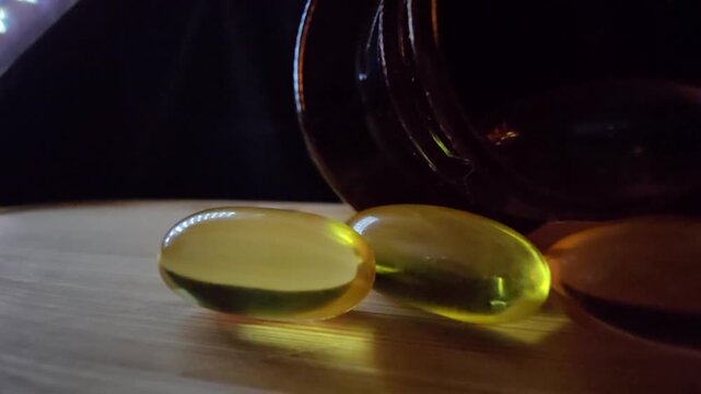 Macro shot of a golden fish oil capsule with soft lighting on a wooden surface, highlighting purity and health.