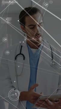 Vertical video: Doctor tapping tablet and responding to pointing hand, HUDs updating medical data