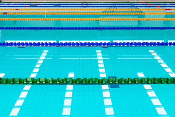 Naklejka premium Track & lanes of a competition swimming pool. Indoor swimming pool with empty lanes. Standard swimming pool & diving pool, water and lines ,