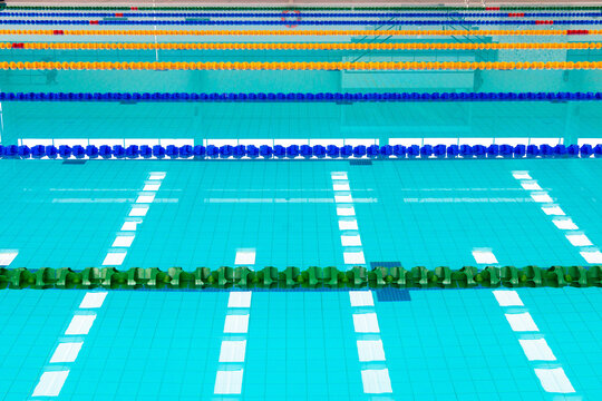 Track & lanes of a competition swimming pool.Indoor swimming pool with empty lanes.Standard swimming pool & diving pool, water and lines ,