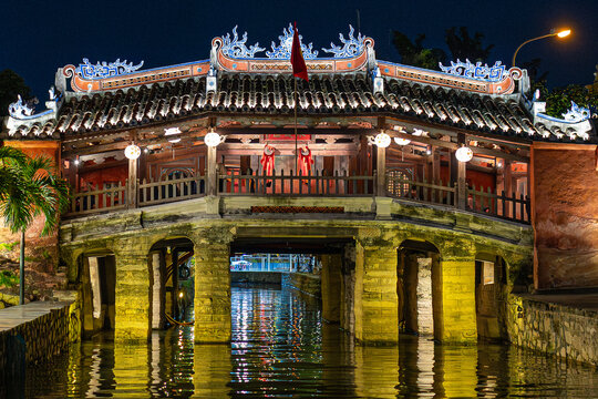 Historic japanese covered bridge over hoai river in hoi an, vietnam, glowing with night lights