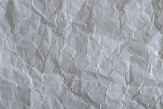Crumpled white waxed paper texture background top view. Wrinkled greaseproof baking paper surface