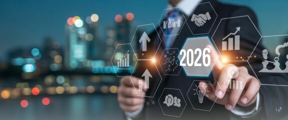 Obraz premium Vision 2026: A business person, navigating a digital interface showcasing strategic plans for the year 2026 against a backdrop of city lights, symbolizes forward-thinking business strategies.