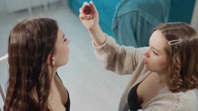 Laughter As Sisters Get Subtle Facial Treatment, Warm Moments Of Sisters Having Lighthearted Beauty Session, Two Sisters Share Joyful Time During Relaxed Makeover With Soft Brushing And Giggles