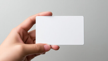 Obraz premium A person's hand holds a blank white card, ready for custom branding or a personalized message.