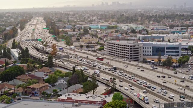 Busy Los Angeles freeway with heavy rush hour traffic and the city skyline in the hazy background