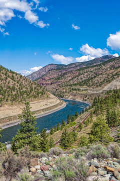 Railroad tracks run along both sides of the river in the Thompson River Valley near Lytton, British Columbia, Canada