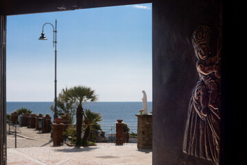 Church door opening revealing ogliastro marina sea view