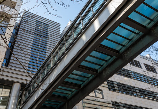Modern glass skybridge connecting contemporary buildings in an urban city environment
