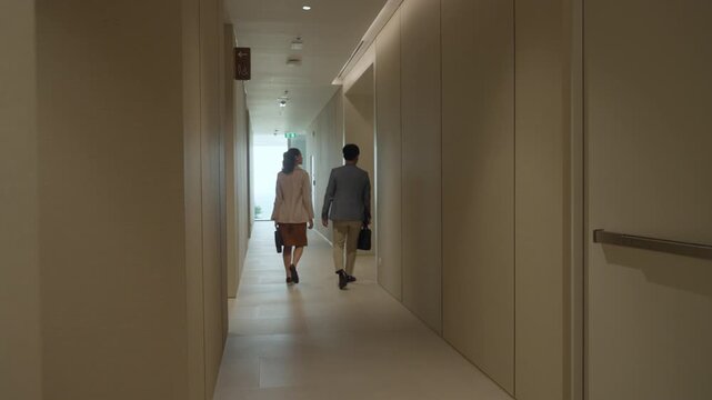 Business finance partnership smart casual coworker office corridor hallway walking toward meeting, corporate energy with calm focus, tidy suit and neat bag signal teamwork, trust, goal driven intent