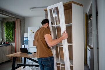 Man assembling furniture, building cabinet for home improvement