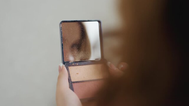 White Woman Examining Reflection In Compact Mirror, Tiny Handheld Glass Showing Eye And Skin Detail, Soft Blurred Foreground, Intimate Inspection, Private Moment Of Finishing Touches