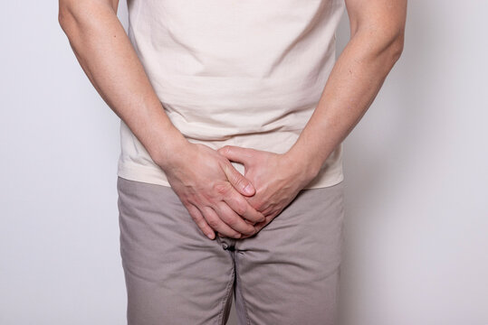 Male health concept. Man holding crotch suffering from pain, burning or itching symptoms of urinary tract infection, prostatitis, bladder inflammation or sexually transmitted infection.