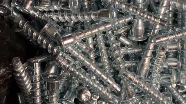 furniture screws confirmats solid background silver color. hardware and fasteners for the assembly and production of furniture close-up.
