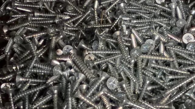 hardware for connecting wooden and metal structures in close-up. silver-colored self-tapping screws in close-up.