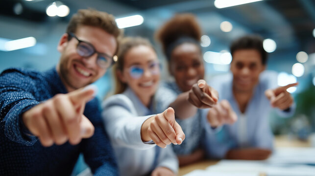 Wide bright close up of a group of young business people from the waist down multiple hands pointing outward toward the camera in a unified gesture from a meeting table bright
