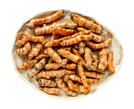 many natural fresh curcuma rhizomes on ceramic plate isolated on white background from Thailand
