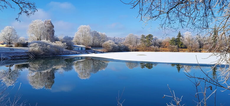 Ein traumhafter Wintermorgen bei Illertissen: Mit dichtem Raureif bedeckte B&auml;ume leuchten vor einem strahlend blauen Himmel und verwandeln die Landschaft in eine glitzernde Eiswelt.