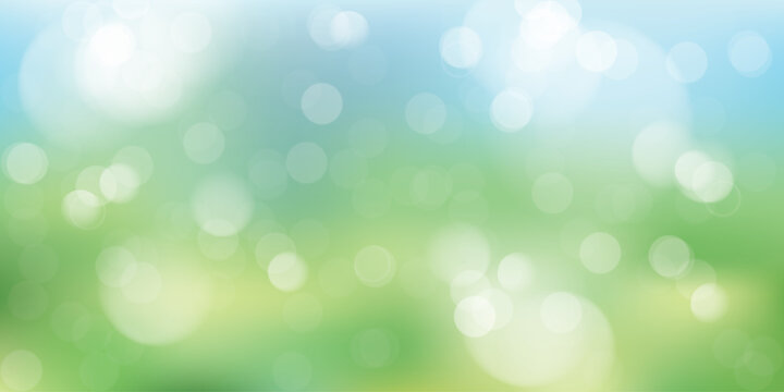 Abstract spring nature background featuring soft defocused bokeh lights over fresh green grass and clear blue sky. Perfect for spring season concepts, Easter designs, and eco-friendly themes.