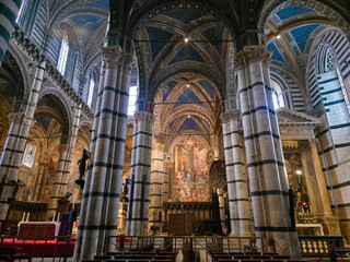 Obraz premium Interior of Siena Cathedral (Duomo di Siena) with Black and White Striped Marble Columns, Italy. Gothic Architecture, Ornate Vaulted Ceiling and Renaissance Frescoes in Tuscany