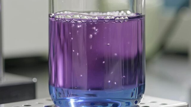 Purple chemical solution bubbling in laboratory glass beaker during experiment, scientific research scene illustrating chemistry analysis, laboratory testing, education, and pharmaceutical development