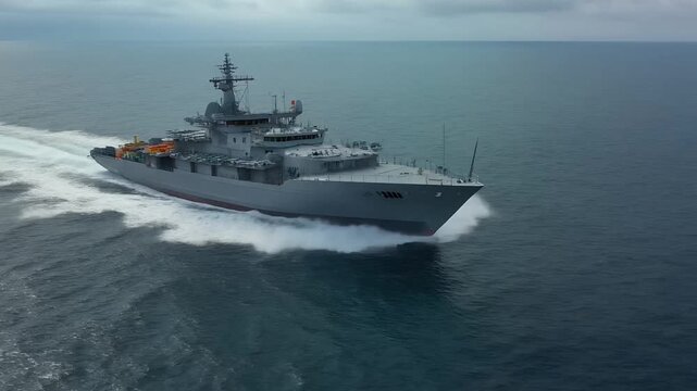 Aerial view of fast naval patrol ship cruising across open sea.