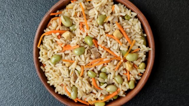 Asian food with rice, edamame, carrots, tofu, and spices. Rice with edamame and carrots as a food background for your design