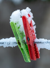 Clothespins on a wire covered in snow. Close-up.
