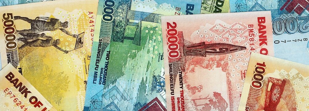 Ugandan shilling paper banknotes pile on table. Uganda UGX currency money bills in big amount. Concept of economics, taxation and banking in Uganda