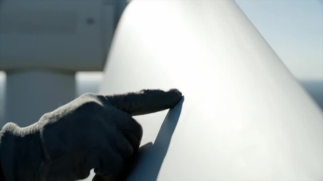 A dedicated engineer performs a vital inspection on a large wind turbine, meticulously assessing its structural components to guarantee optimal performance and longevity in renewable energy operations