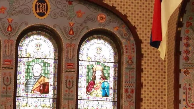 Static interior shot of a stained glass window and vintage wall lamps in synagogue