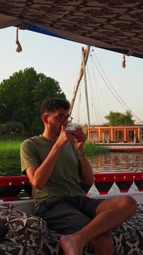 Traveler Having tea on Authentic Nile River Sailing on Traditional Felucca