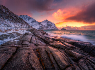 Dramatic winter seascape on the Lofoten Islands in Norway with waves crashing over coastal rocks...