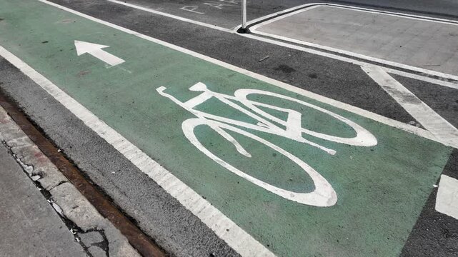 E-bike with child on back rides diagonally through shot of green bike lane
