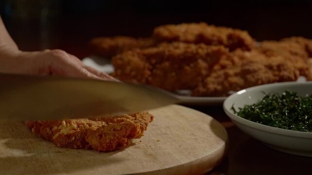 Chef Slicing Golden Crispy Fried Chicken Cutlet Preparing Lemon Cream Sauce Dish in Kitchen