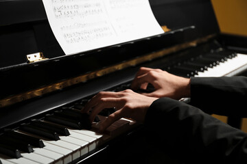 Musician playing piano indoors, closeup. Musical instrument © New Africa