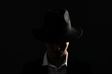 Man in stylish hat on dark background
