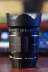 Professional camera lens with hood for photography and videography equipment on dark background © PhotoBank