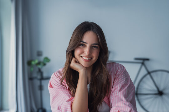 Positive beautiful young latin woman in casual shirt looking at camera, smiling. Confident pretty 30s freelance businesswoman corporate head shot female business portrait