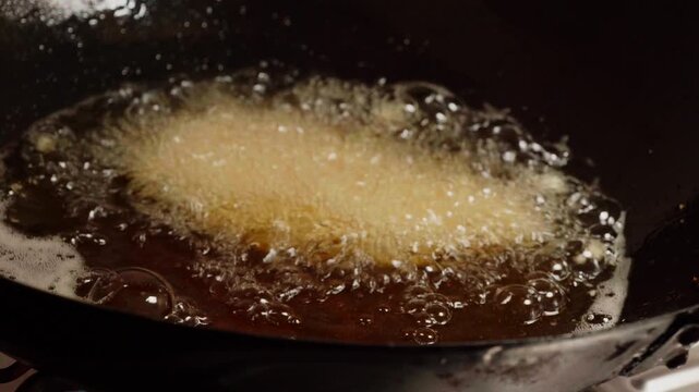 Dropping Breaded Chicken into Hot Oil Frying in Pan Close Up Cooking Process Crispy Fried Chicken Preparation
