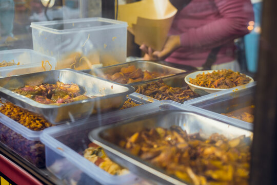 glass display case at a buffet food stall on the side of an Indonesian road