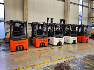 warehouse electric forklifts stackers lined up in a row © Serhii
